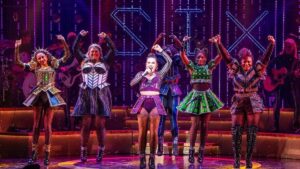 Women in costume singing on the stage for SIX on Broadway